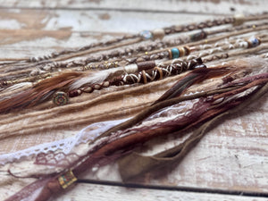 sandy blonde dreadlocks with brown and white decorations