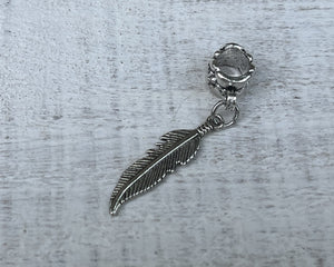 Feather dreadlock bead on wooden background